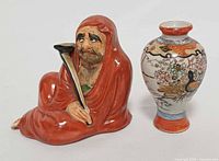 Front view Daruma figurine and miniature vase