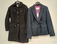 Front view of black peacoat and navy blazer on hangers
