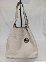 Front view of cream leather Michael Kors hobo with MK charm