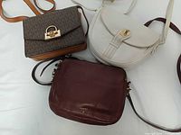 Front view of three crossbody bags showing brands and styles