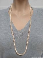 Necklace worn long to show full 30.5-inch strand of pearls
