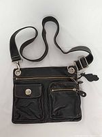 Front view showing pockets, strap, hardware