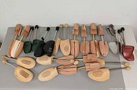 All pairs of shoe trees laid out on table