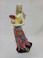 Front three-quarter view of figurine showing bouquet and floral gown