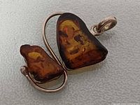 Front view of pendant showing amber stones and silver setting
