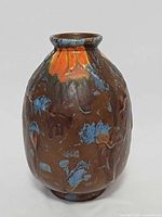 Front view of ovoid brown ceramic vase with blue and orange drip glaze
