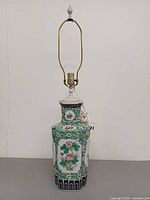 Full view of porcelain table lamp with harp and finial