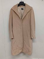 Front view of beige wool coat on hanger