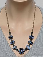 Necklace on display bust showing bead design and chain
