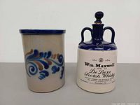 Front of crock with foliate cobalt decoration and whisky bottle with printed label