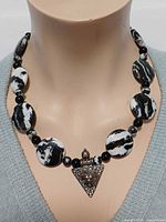 Necklace on mannequin showing bead arrangement and pendant