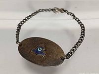 Full view of bracelet top with oval plaque showing enamel crest