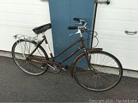 Full side view of bicycle showing frame, wheels, handlebars, saddle and rear rack