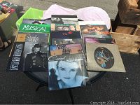 Photo showing selection of vintage vinyl records on round table including Miki Howard 'Musical', Carmel, Harry Chapin, Michael Jackson, and more.
