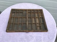 Full view of the wooden printers tray showing the multiple compartments arranged in a grid pattern, placed on a light purple cloth.