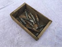 View of wooden box with metal sap spigots inside showing condition and quantity.