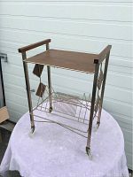 Front view of the record stand with wood top and metal frame showing front angled wood holders and bottom rack