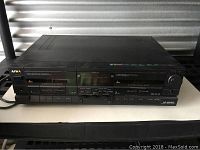 Front view of Aiwa AD-WX808 stereo cassette deck showing dual cassette compartments, control buttons, and brand labels