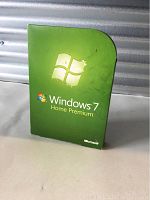 Front view of the Windows 7 Home Premium retail box, showing bright green packaging with Windows logo and edition name.