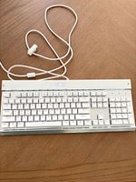 Top view of white full-size mechanical keyboard with attached USB cable
