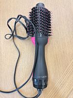 Full view of Revlon hot air brush showing bristle head, handle, and power cord