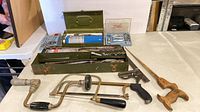 Frontal view of all items laid out: toolbox open showing contents, torch kit, socket sets, braces, saws, square