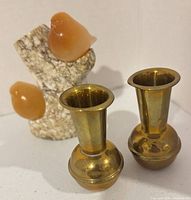 Pair of brass bud vases with stone bird sculpture front view