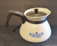 Left side view showing blue cornflower motif, handle, lid and overall condition