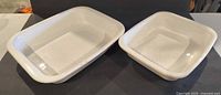 Two white rectangular CorningWare dishes, side by side, interiors visible