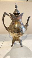 Full view of silver plate coffee pot on stand