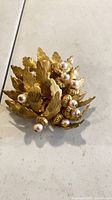 Front view showing gold-tone leaves and faux pearls