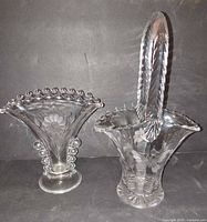 Front view showing both the trumpet vase and handled basket, highlighting etched floral designs and rim details