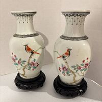 Front view of both porcelain vases on stands showing bird and floral motif