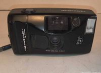 Front view of Ricoh One Take Easy camera showing lens, flash, branding