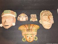 All five terracotta masks laid out for full view