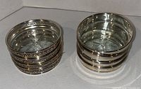 Two stacks of coasters showing ornate and plain rim styles