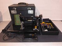 Singer 221-1 sewing machine with case and accessories displayed
