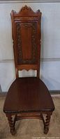 Full front view of chair showing carved back, seat, and barley twist legs
