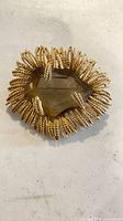 Front view of brooch showing smoky quartz center and rope-twist sunburst frame