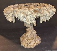 angled view showing entire marble compote with leaf-carved rim and pedestal