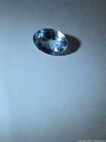 Oval faceted aquamarine loose stone on neutral background