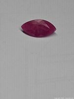 Marquise ruby on flat surface showing colour and faceting