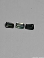 Three rectangular octagon-cut sapphires on neutral background