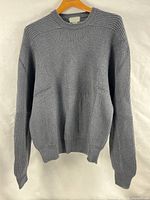 Front view of charcoal grey ribbed sweater hanging