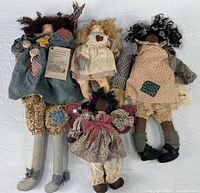 All four cloth dolls laid out for size comparison