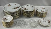 All stacks of dinnerware and two glass dishes displayed on table