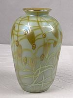 Full view of iridescent pale green vase with gold pulled feather and vine decoration