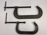 Both steel C-clamps side by side, showing full shape and screws