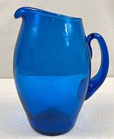 Full view of cobalt blue glass pitcher showing spout