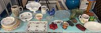 Full shelf view showing entire assortment of plates, glassware, ceramics and rocks